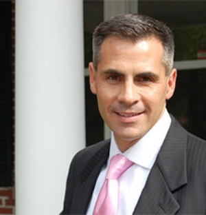 A man in suit and tie standing outside.