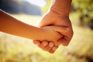 A close up of two hands holding each other