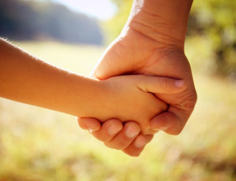 A close up of two hands holding each other