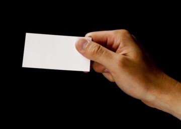 A person holding a white card in their hand.